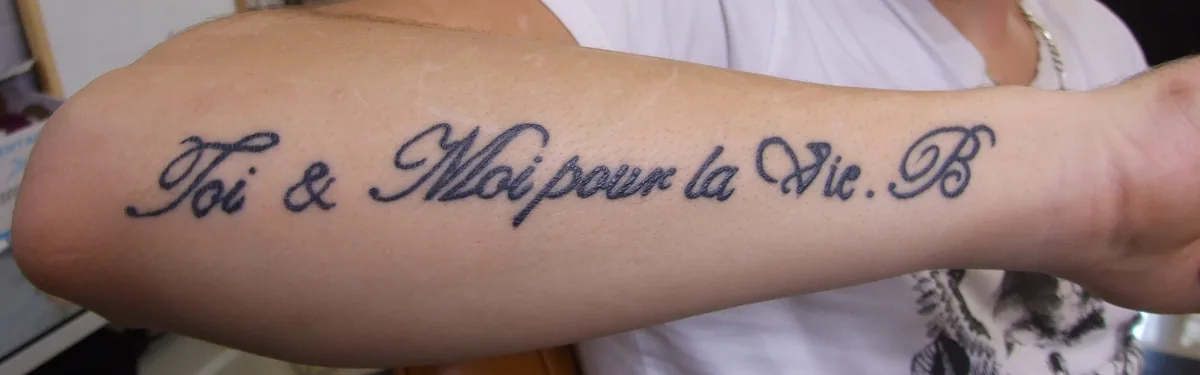 Lettrage « Toi & Moi pour la Vie » sur l'avant-bras, avant le cover up