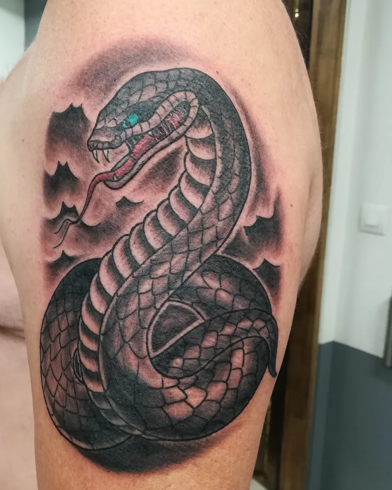 Serpent en noir et gris recouvrant un petit scorpion sur le haut du bras, cover up de Tof
