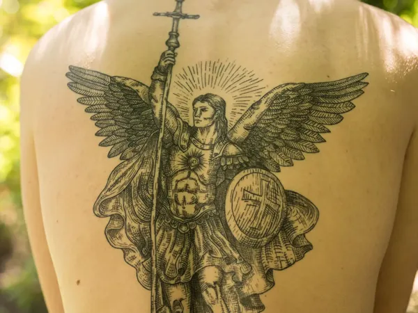 Saint Michel face au démon, tatouage de dos réalisé par Flo chez Tattoo on Move