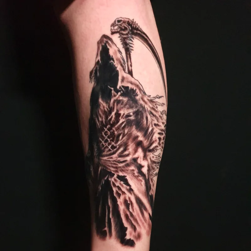 Faucheuse encapuchonnée tenant une faux, en noir et gris, sur le mollet, tatouage blackwork