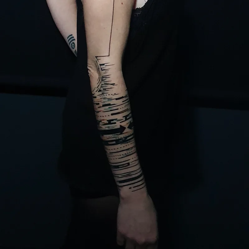 Bandes de traits noirs horizontaux en manchette sur l'avant-bras, tatouage graphique