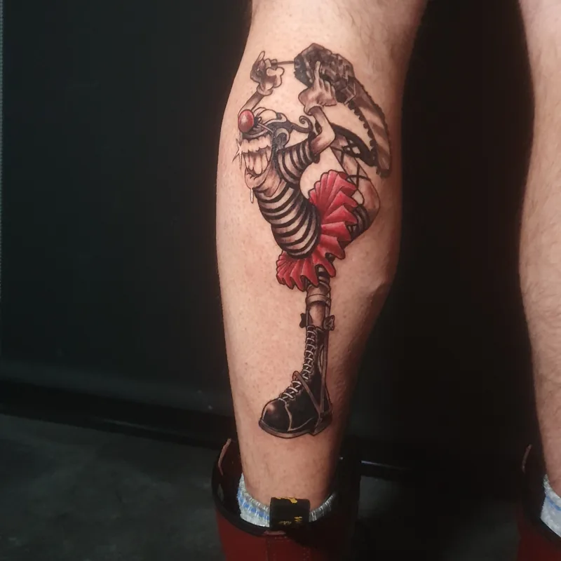 Clown en collants rayés, tutu rouge et bottes, sur le mollet, tatouage new school