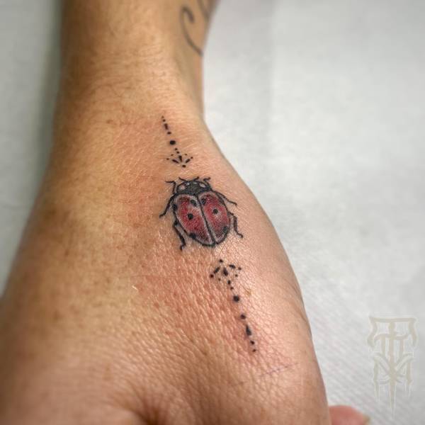 patricia_noirdejais_noir-de-jais_tattoo-on-move_fine-line-tattoo_coccinelle_main_pouce_ornements_original